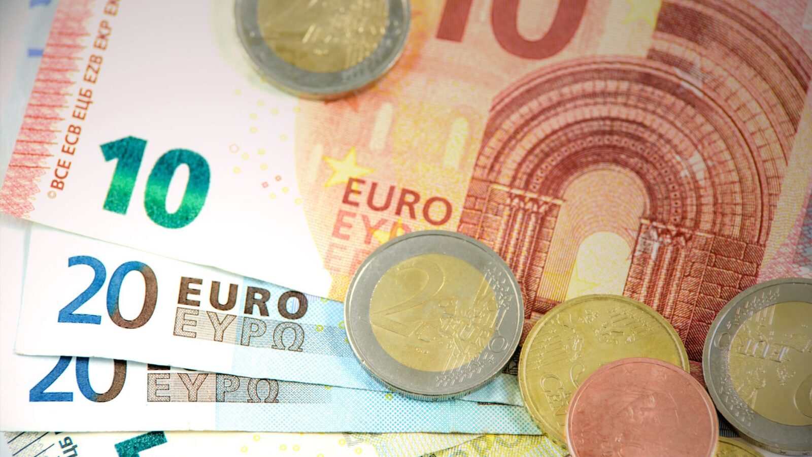 Gedetailleerde opname van Euro bankbiljetten en munten met valuta denominaties.