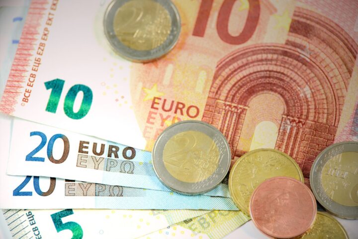 Gedetailleerde opname van Euro bankbiljetten en munten met valuta denominaties.