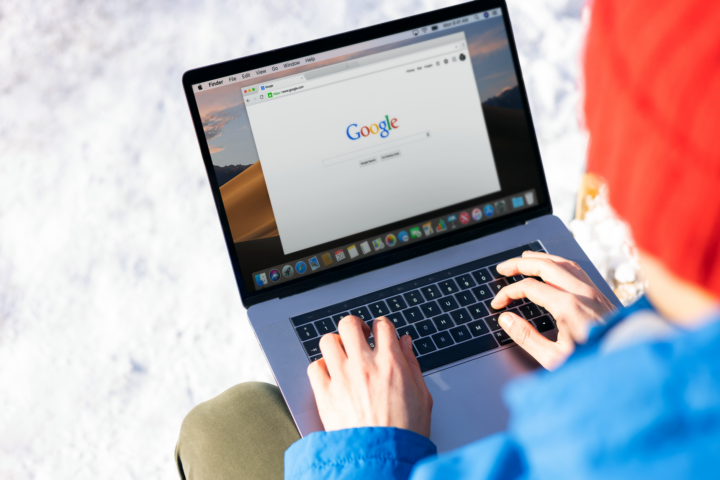 Individu die buiten op een laptop typt in de sneeuw, toegang tot internet.