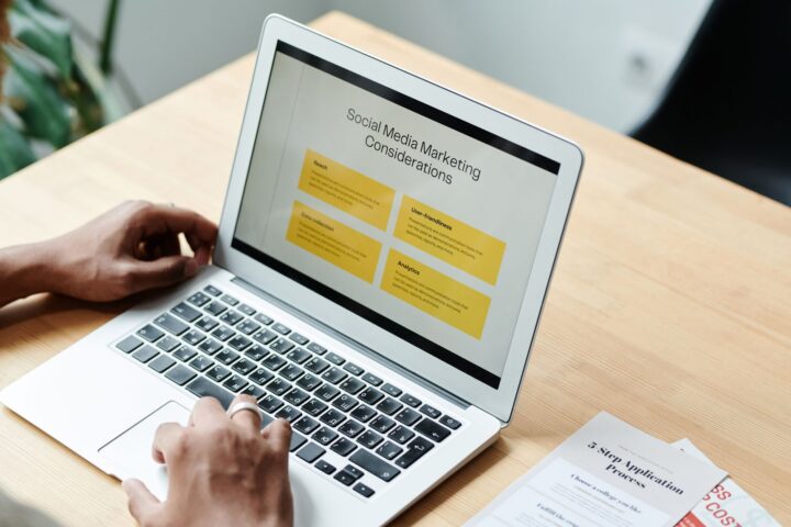 Een persoon die thuis een laptop gebruikt om sociale-mediamarketingstrategieën te herzien.